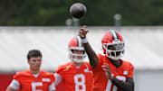 Cleveland Browns quarterback Shedeur Sanders (12) throws as rookie quarterback Dillon Gabriel (5) and Kenny Pickett (8) look on during practice at NFL minicamp.